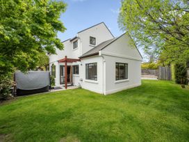 A house with grass and trees in the garden at Kokomea House - Wanaka Holiday Home in Wanaka