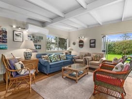 A living room with a sofa and armchairs at Coastal Cove – Waipu Cove Holiday Home, Waipu Cove
