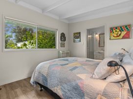 A bedroom with a bed and window at Coastal Cove – Waipu Cove Holiday Home Waipu Cove