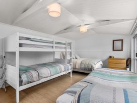 A bedroom with bunk beds and a double bed at Coastal Cove – Waipu Cove Holiday Home, Waipu Cove