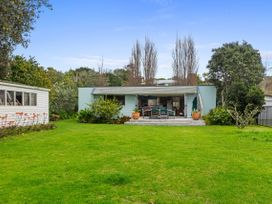 A house with a deck and garden at Coastal Cove – Waipu Cove