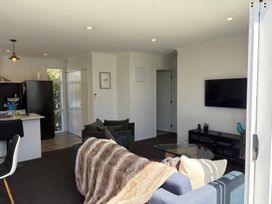 A living room with a sofa and television at Treasure on Tuscan - Martinborough Holiday Home
