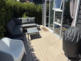 An outdoor patio with a sectional sofa and coffee table at Treasure on Tuscan - Martinborough