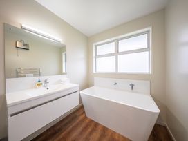 A bathroom with a bathtub and sink at Fiordland Getaway - Te Anau Holiday Home in Fiordland