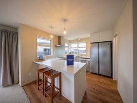 A kitchen with a sink and refrigerator at Fiordland Getaway - Te Anau Holiday Home Fiordland
