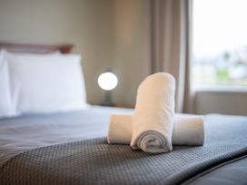 A bedroom with a bed and towels at Fiordland Getaway - Te Anau Holiday Home, Fiordland