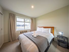 A bedroom with a bed and a window at Fiordland Getaway - Te Anau Holiday Home, Fiordland