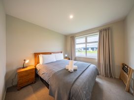 A bedroom with a bed and window at Fiordland Getaway - Te Anau Holiday Home Fiordland