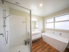 A bathroom with a shower and bathtub at Fiordland Getaway - Te Anau Holiday Home Fiordland