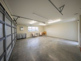 A garage with a window, workbench, and chairs at Fiordland Getaway - Te Anau Holiday Home Fiordland