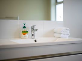 A bathroom sink with soap and towels at Fiordland Getaway - Te Anau Holiday Home Fiordland