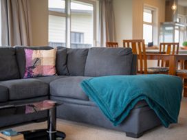 A living room with a sofa and dining table at Fiordland Getaway - Te Anau Holiday Home in Fiordland