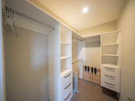 A closet with shelving, drawers, and hanging space at Fiordland Getaway - Te Anau Holiday Home Fiordland