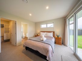 A bedroom with a bed and closet at Fiordland Getaway - Te Anau Holiday Home, Fiordland