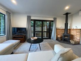 A living room with a sofa and television at Bushside Cottage - Akaroa Holiday Home in Akaroa