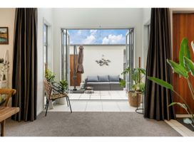 An indoor living area showing a view to an outdoor sitting space at Lakeview Luxury - Taupo Holiday Apartment, Taupo Central