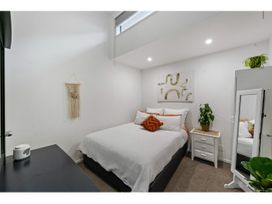 A bedroom with a bed and nightstand at Lakeview Luxury - Taupo Holiday Apartment, Taupo Central