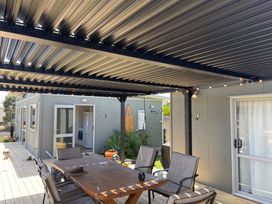An outdoor dining area with a table and chairs at Kõpuha on Rangiora - Matarangi