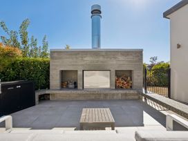 An outdoor area with fireplace and seating space at Casa Central - Wanaka Holiday Home, Wanaka