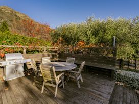 An outdoor seating area with a table and chairs at Frankton Favourite - Queenstown Holiday Home in Queenstown