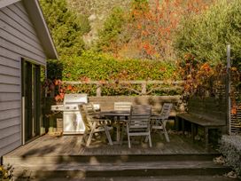 An outdoor deck with a table and chairs at Frankton Favourite - Queenstown Holiday Home in Queenstown