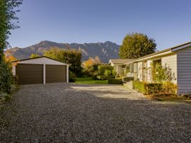 An outdoor view of a house and garage with mountains in the background at Frankton Favourite - Queenstown Holiday Home, Queenstown