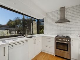 A kitchen with a sink, stove, and dishwasher at Frankton Favourite - Queenstown Holiday Home in Queenstown