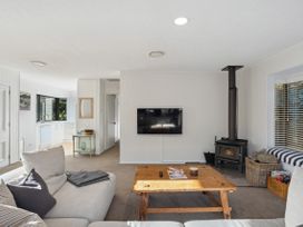 A living room with a sofa and coffee table at Frankton Favourite - Queenstown Holiday Home in Queenstown