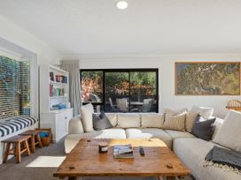 A living room with a sofa and coffee table at Frankton Favourite - Queenstown Holiday Home