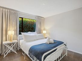 A bedroom with a bed and nightstand at Frankton Favourite - Queenstown Holiday Home, Queenstown