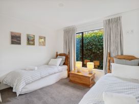 A bedroom with two single beds and a window at Frankton Favourite - Queenstown Holiday Home in Queenstown