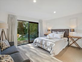 A bedroom with a bed and sofa at Frankton Favourite - Queenstown Holiday Home in Queenstown