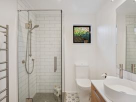A bathroom with shower, toilet, sink and window at Frankton Favourite - Queenstown Holiday Home