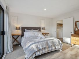 A bedroom with a bed and nightstands at Frankton Favourite - Queenstown Holiday Home, Queenstown