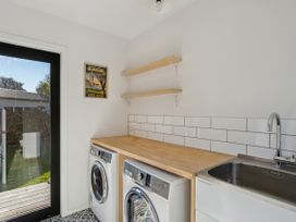 A laundry room with washing machine and dryer at Frankton Favourite - Queenstown Holiday Home in Queenstown