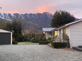 A house and garage with mountains in the background at Frankton Favourite - Queenstown Holiday Home, Queenstown
