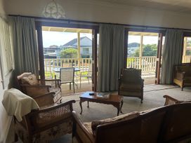 A living room with chairs and a table at The Beach House - Paihia Holiday Home