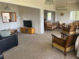 A living room with a television and seating arrangements at The Beach House - Paihia Holiday Home in Paihia
