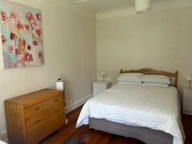 A bedroom with a bed and nightstands at The Beach House - Paihia Holiday Home in Paihia