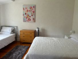 A bedroom with two beds and a dresser at The Beach House - Paihia
