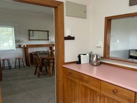 A kitchen with a counter, kettle, and coffee machine at The Beach House - Paihia
