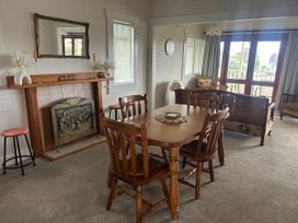 A dining room with a table and chairs at The Beach House - Paihia