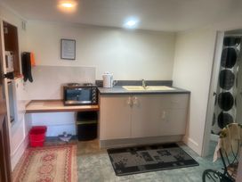 A kitchen with a sink and microwave at The Beach House - Paihia