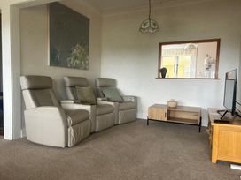 A living room with recliners and a coffee table at The Beach House - Paihia Holiday Home