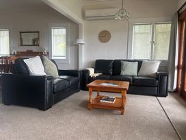 A living room with sofas and a coffee table at The Beach House - Paihia Holiday Home, Paihia