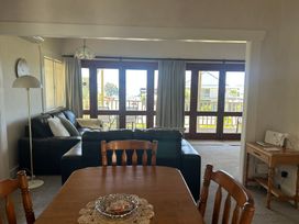 A living room with a sofa and dining table at The Beach House - Paihia