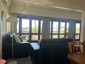A living room with a sofa and lamp at The Beach House - Paihia