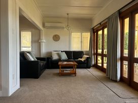 A living room with a black sofa and coffee table at The Beach House - Paihia Holiday Home in Paihia