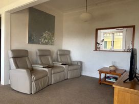 A living room with recliner chairs and a television at The Beach House - Paihia Holiday Home
