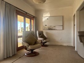 A living room with chairs and wall art at The Beach House - Paihia